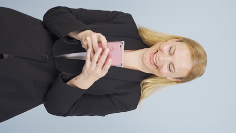 Vertical-video-of-Business-woman-texting-on-the-phone.-Happy-emoticon.